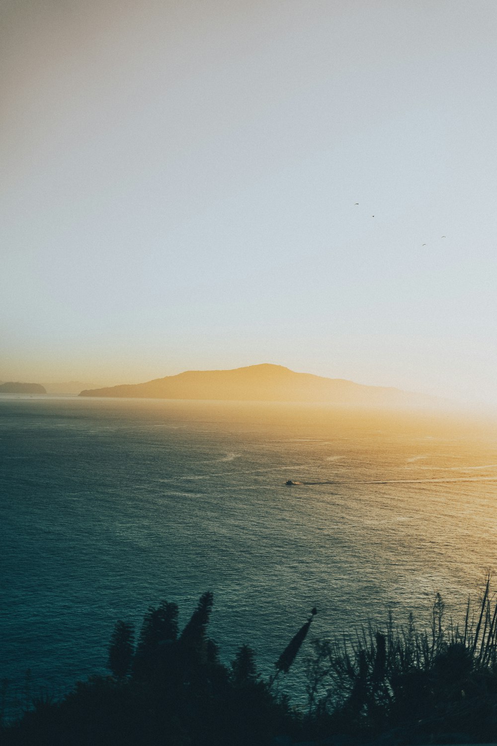 body of water near mountain during daytime