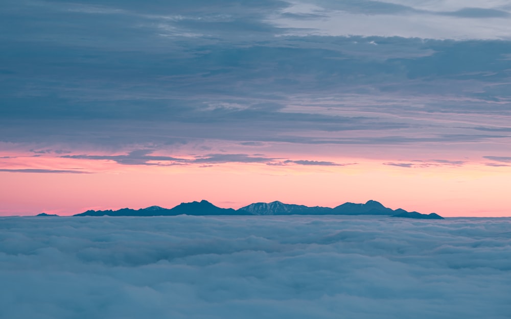 mountains covered with snow under cloudy sky during daytime