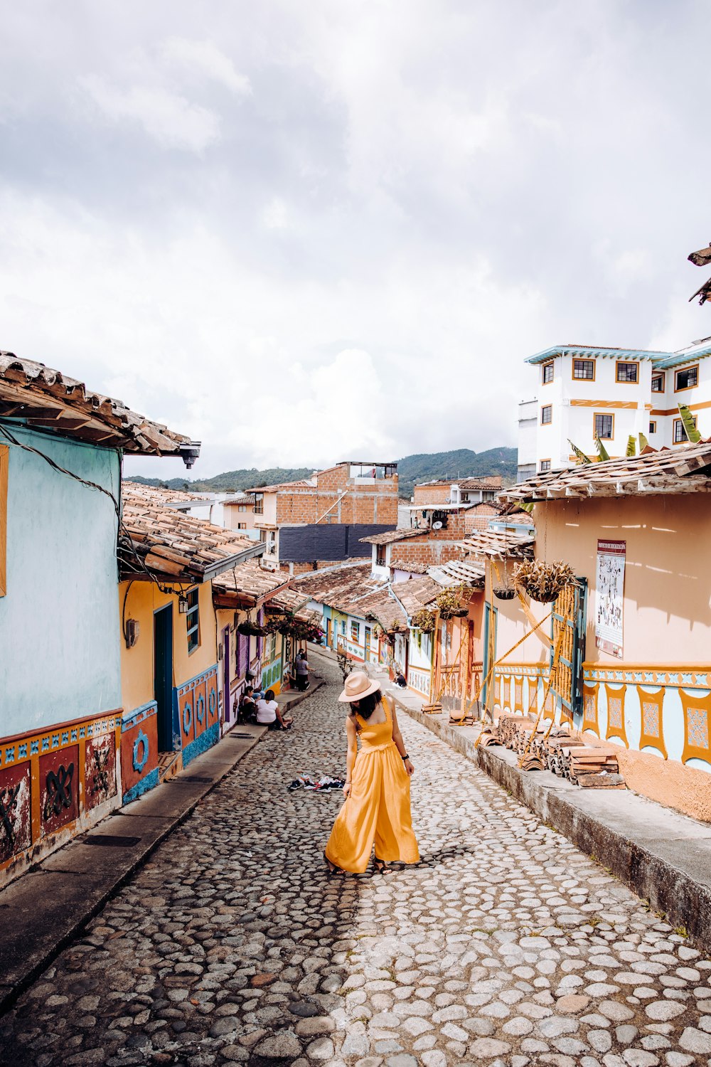 woman in yellow dress walking on street during daytime