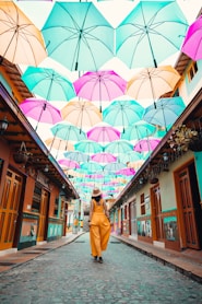 woman in brown coat holding umbrella walking on street during daytime