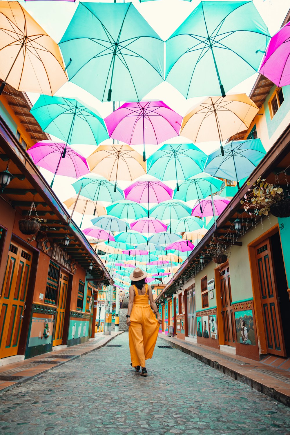갈색 코트를 입은 여자는 낮에 거리를 걷고 있는 우산을 들고 있다