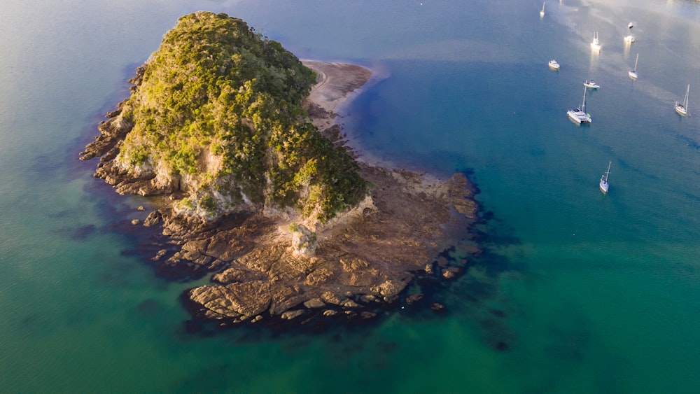 green and brown rock formation on blue sea water during daytime