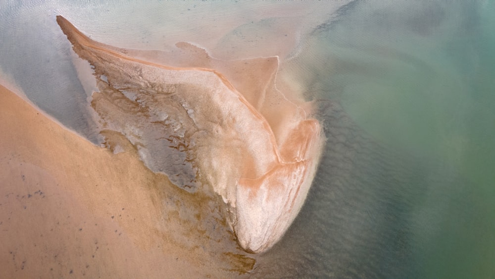 brown rock formation near body of water during daytime