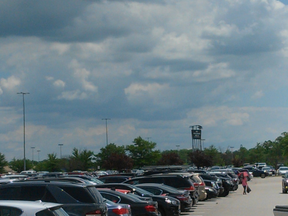 cars parked on parking lot under gray clouds during daytime