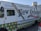 A New Orleans-themed food truck is parked on a street. It features vibrant designs, including Mardi Gras bead graphics and a fleur-de-lis motif. The truck's side promotes corporate catering, weddings, festivals, and other events, with contact information for locations like Harvey and Covington. Social media icons are displayed at the top left corner.