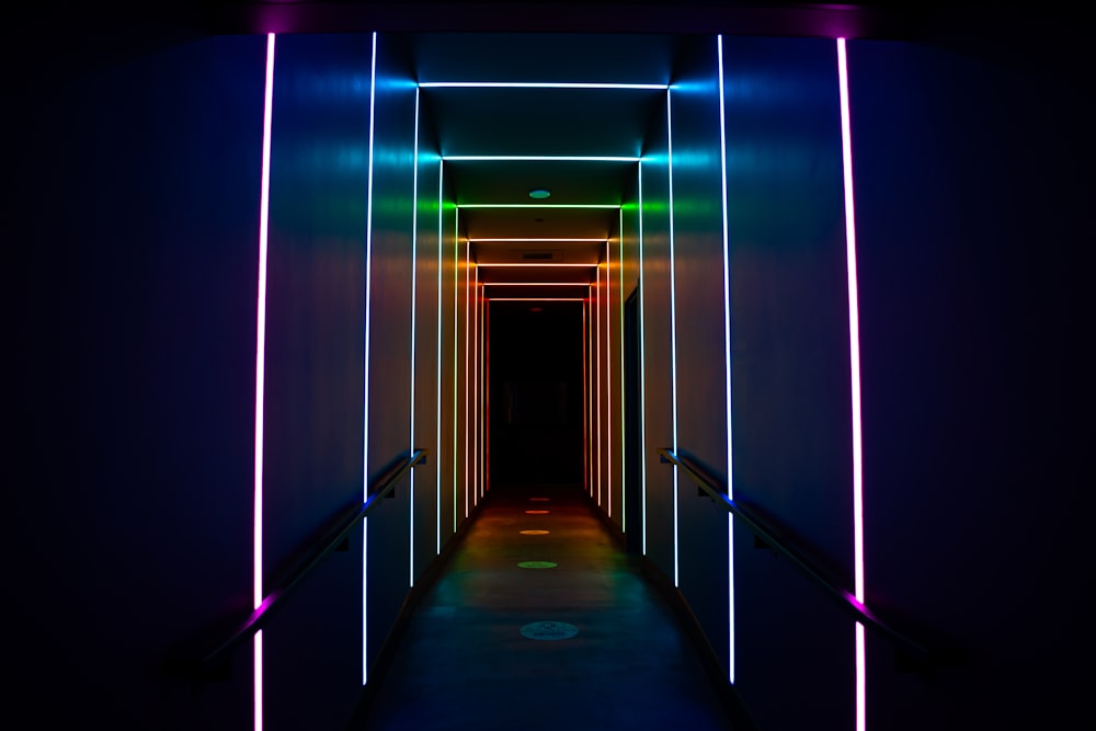 Un largo pasillo con luces de neón en las paredes