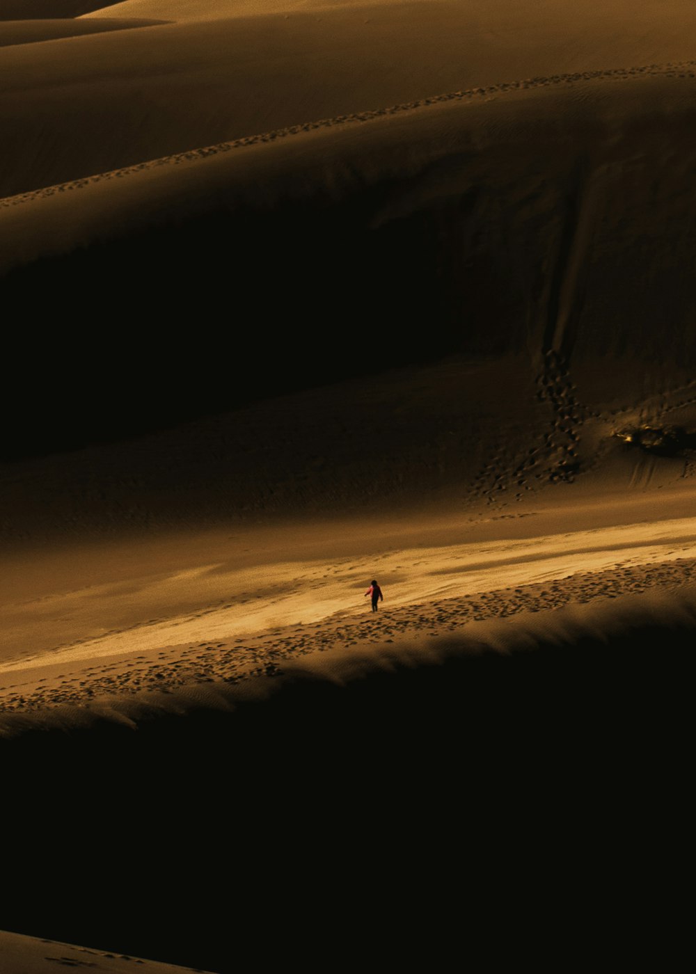 person walking on sand during night time