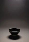 Close-up of a serene clay bowl with natural textures and soft lighting.