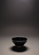 A water bowl for pets with clean lines and a subtle glaze, placed on a concrete floor.