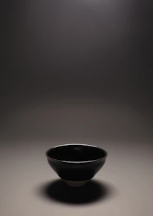 A serene close-up of a smooth, hand-thrown clay bowl with soft natural light highlighting its subtle texture.