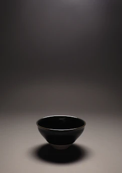 A sleek stainless steel plate and bowl set reflecting soft kitchen light