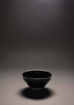 A water bowl for pets with clean lines and a subtle glaze, placed on a concrete floor.