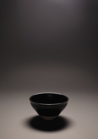 A softly lit close-up of a handmade ceramic bowl with subtle textures.