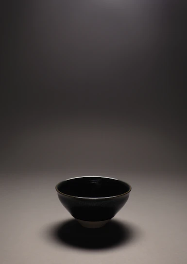 A sleek stainless steel plate and bowl set reflecting soft kitchen light