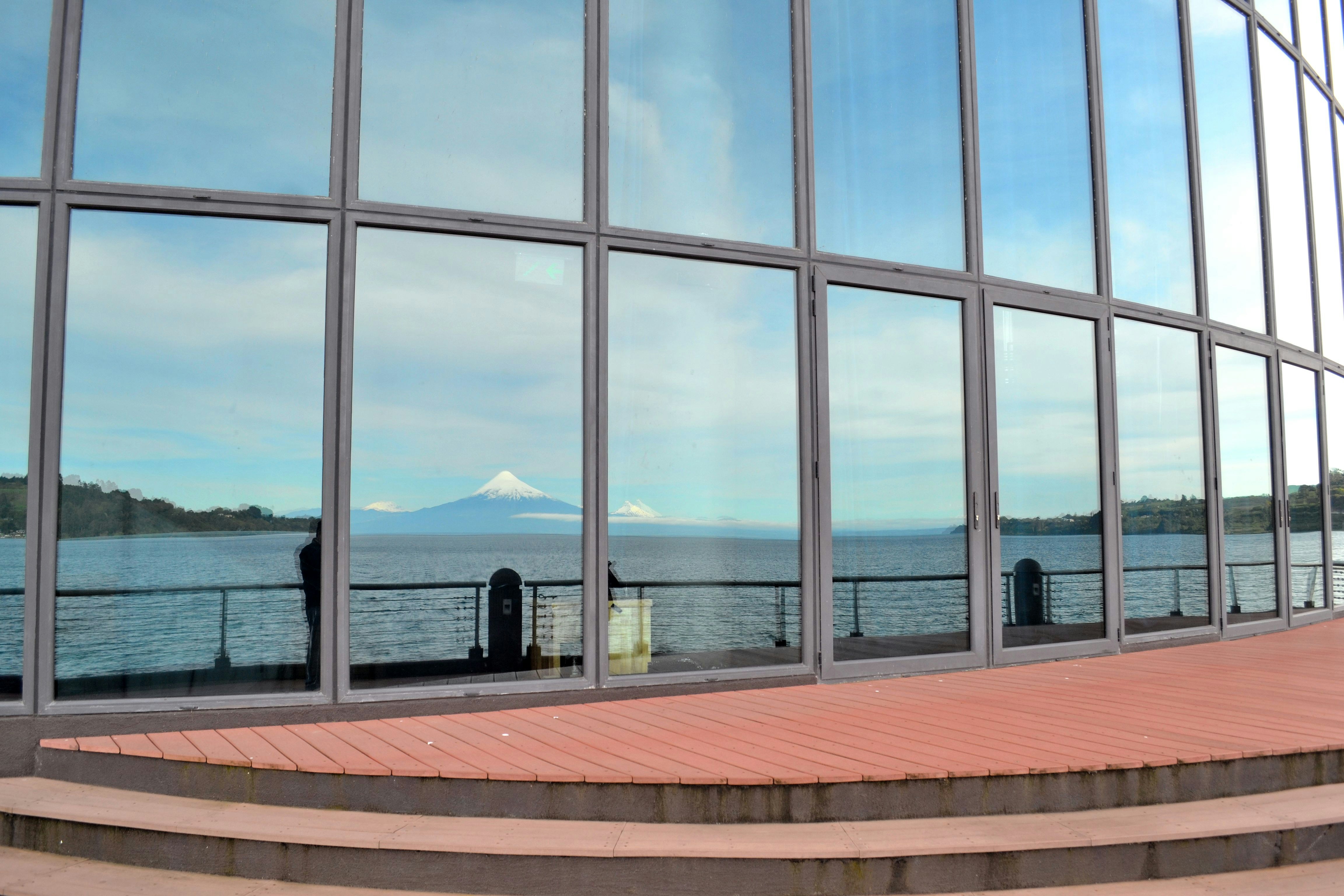 person sitting on bench near body of water during daytime, Teatro del Lago