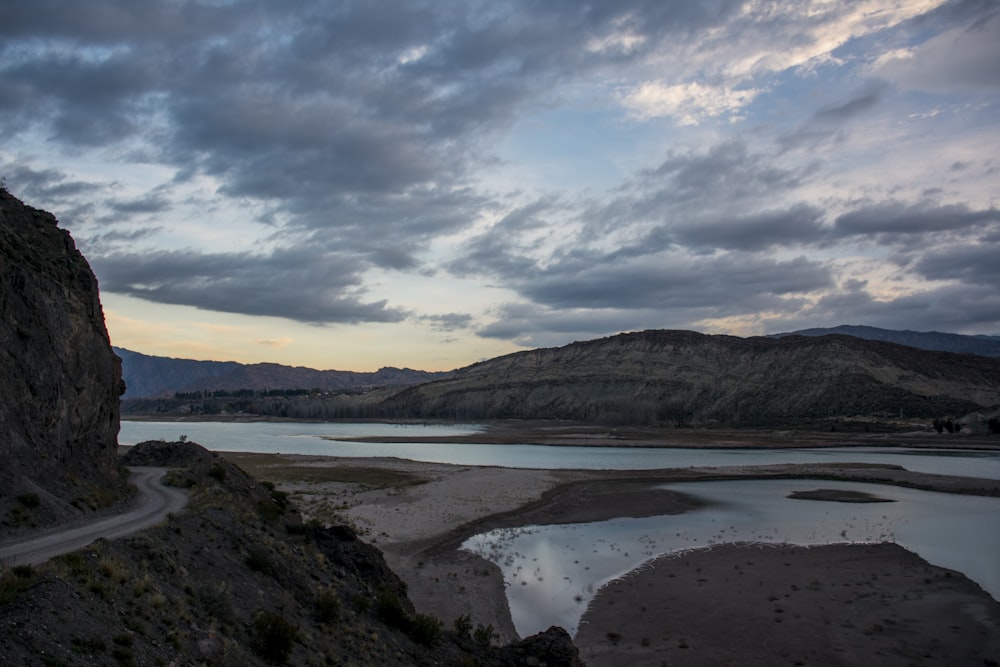 Lago en medio de montañas bajo cielo nublado