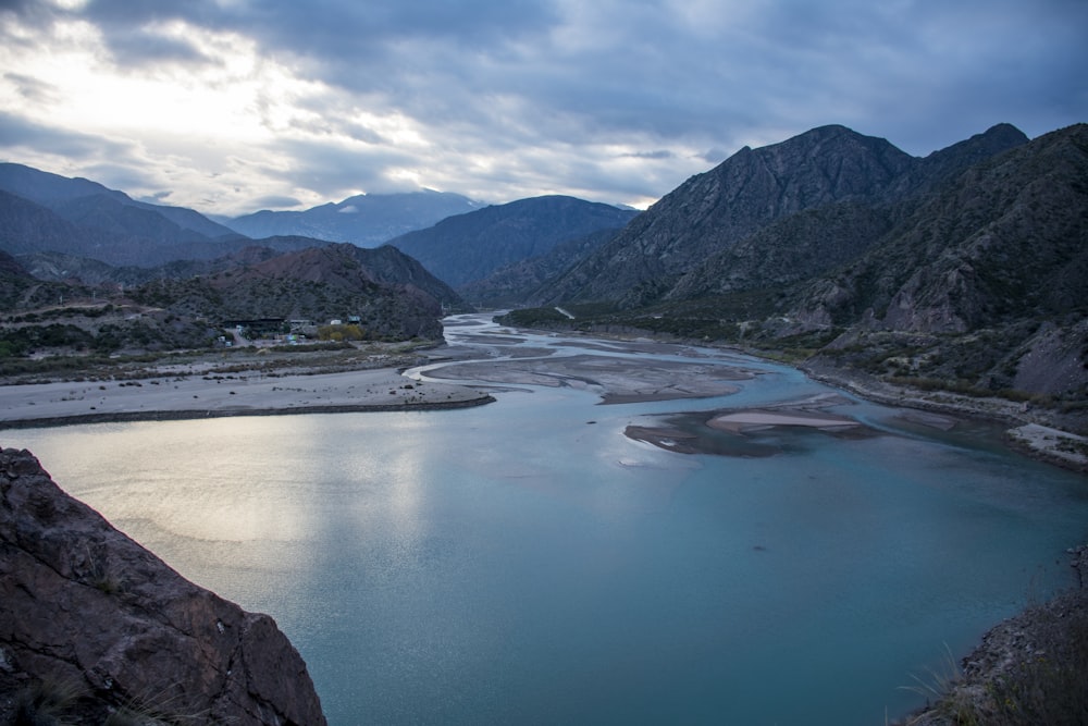 Lago azul cerca de las Montañas Verdes bajo el cielo azul durante el día