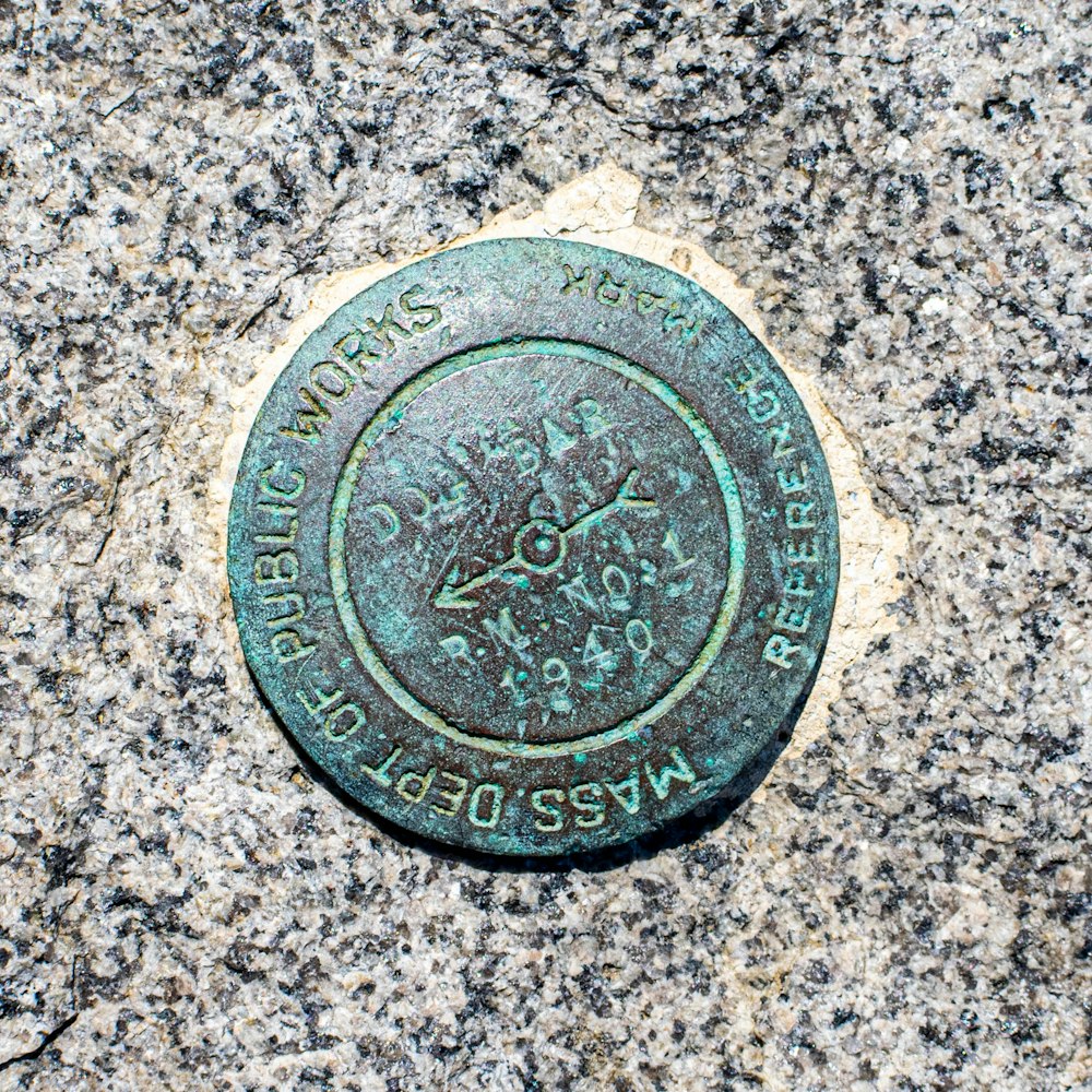 silver round coin on gray marble table