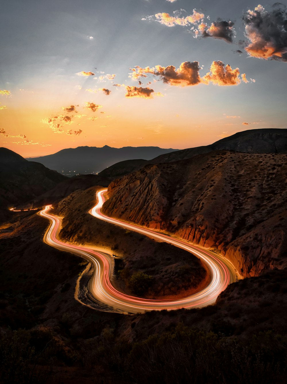 aerial view of road between mountains during sunset