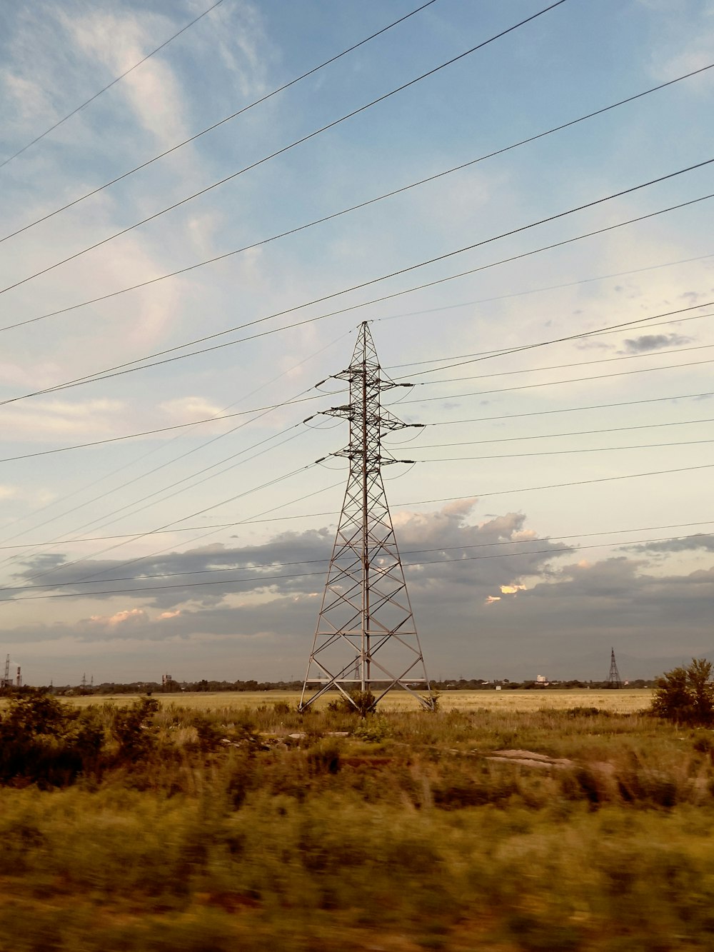 a tall power pole sitting in the middle of a field