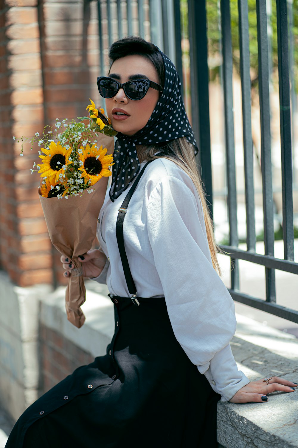 woman in white blazer and black skirt wearing black sunglasses