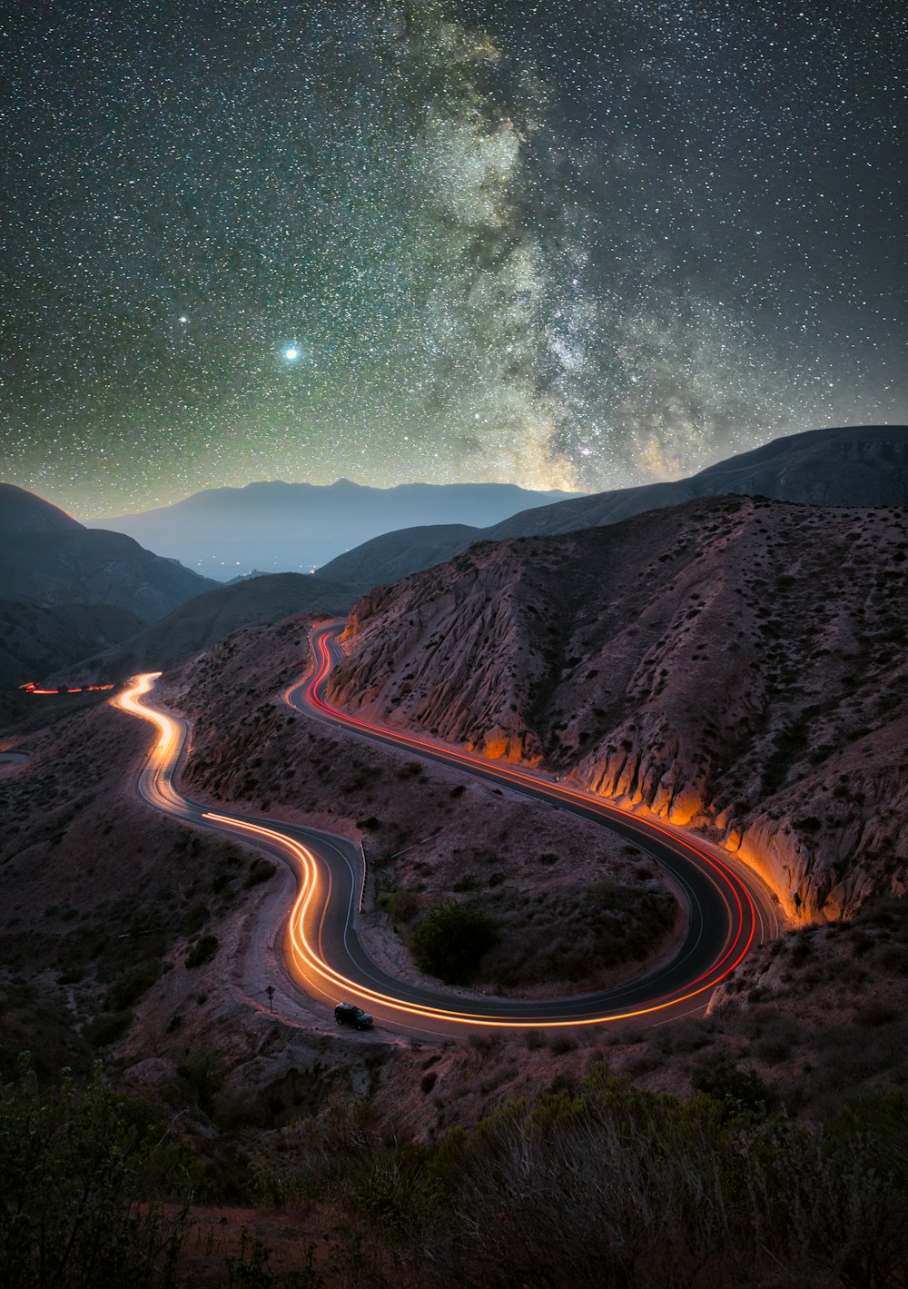 Graue Asphaltstraße zwischen den Brown Mountains während der Nachtzeit