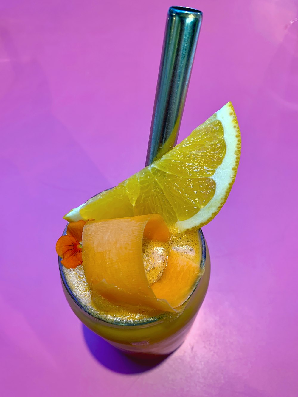 orange fruit on purple glass cup