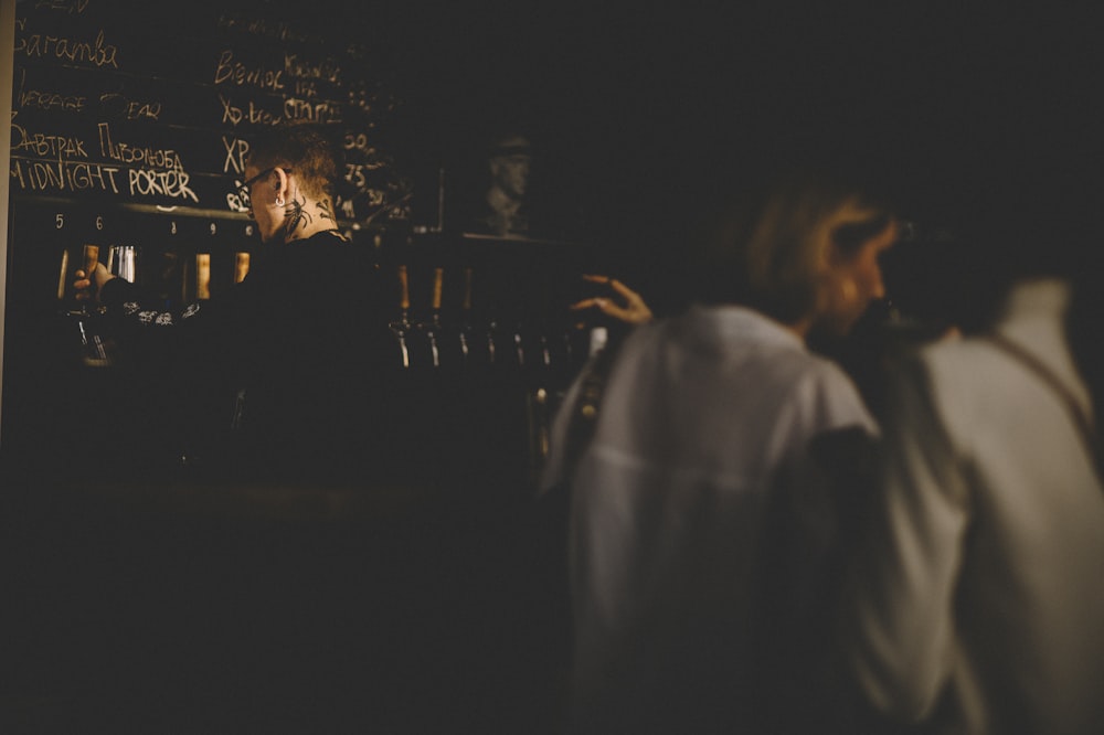 man in white dress shirt standing near woman in black dress