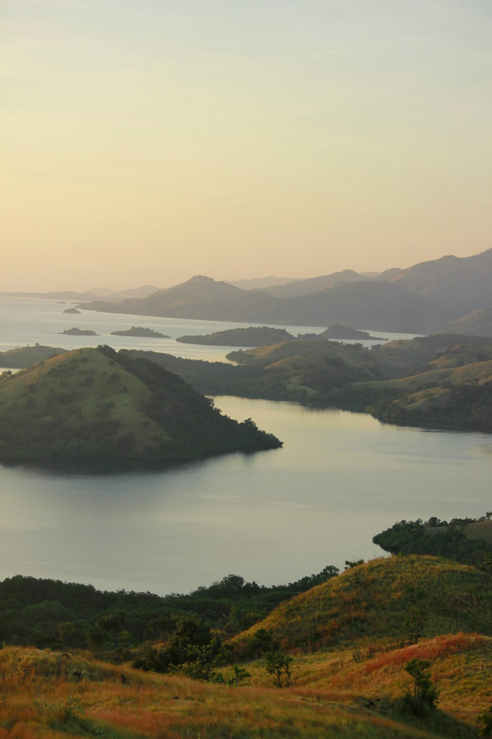 green mountain beside body of water during daytime