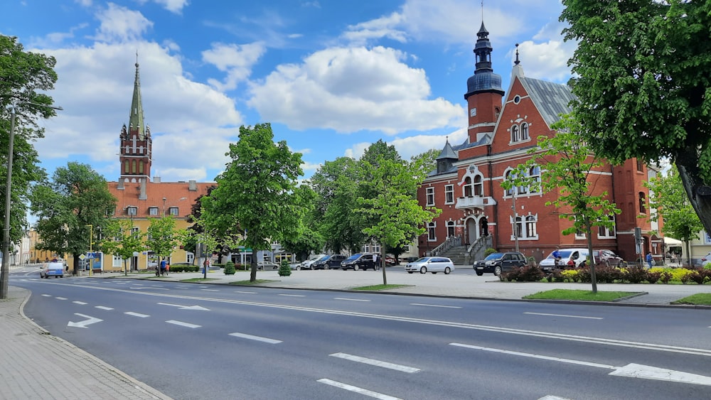 cars parked on street near trees and buildings during daytime