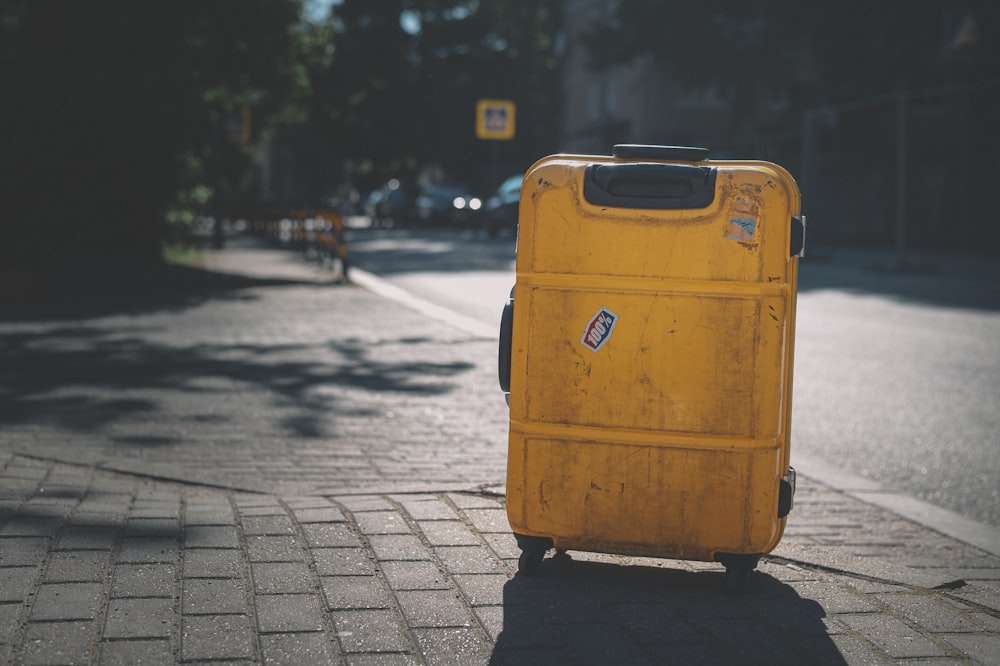 yellow plastic trash bin on sidewalk during daytime