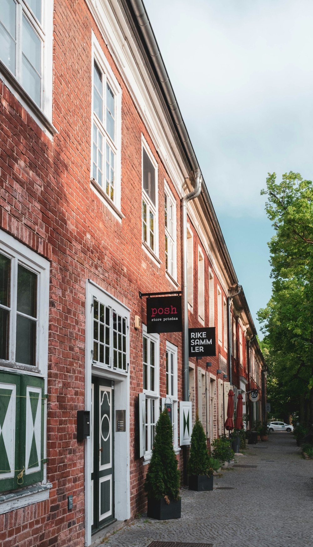 brown brick building with green trees in front