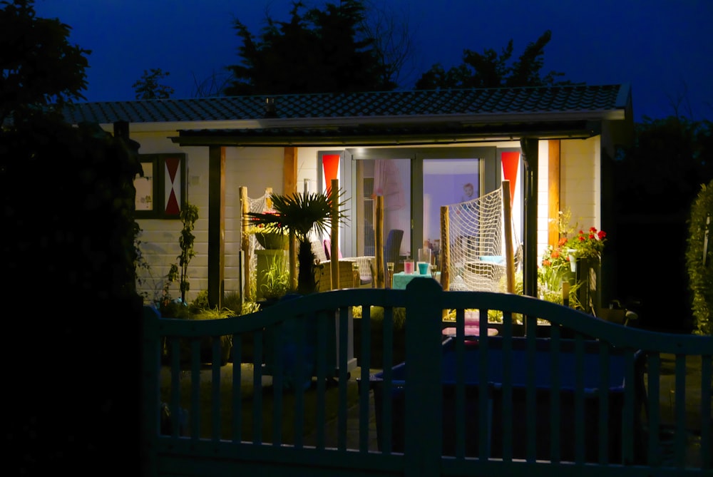 brown wooden fence near green trees during night time