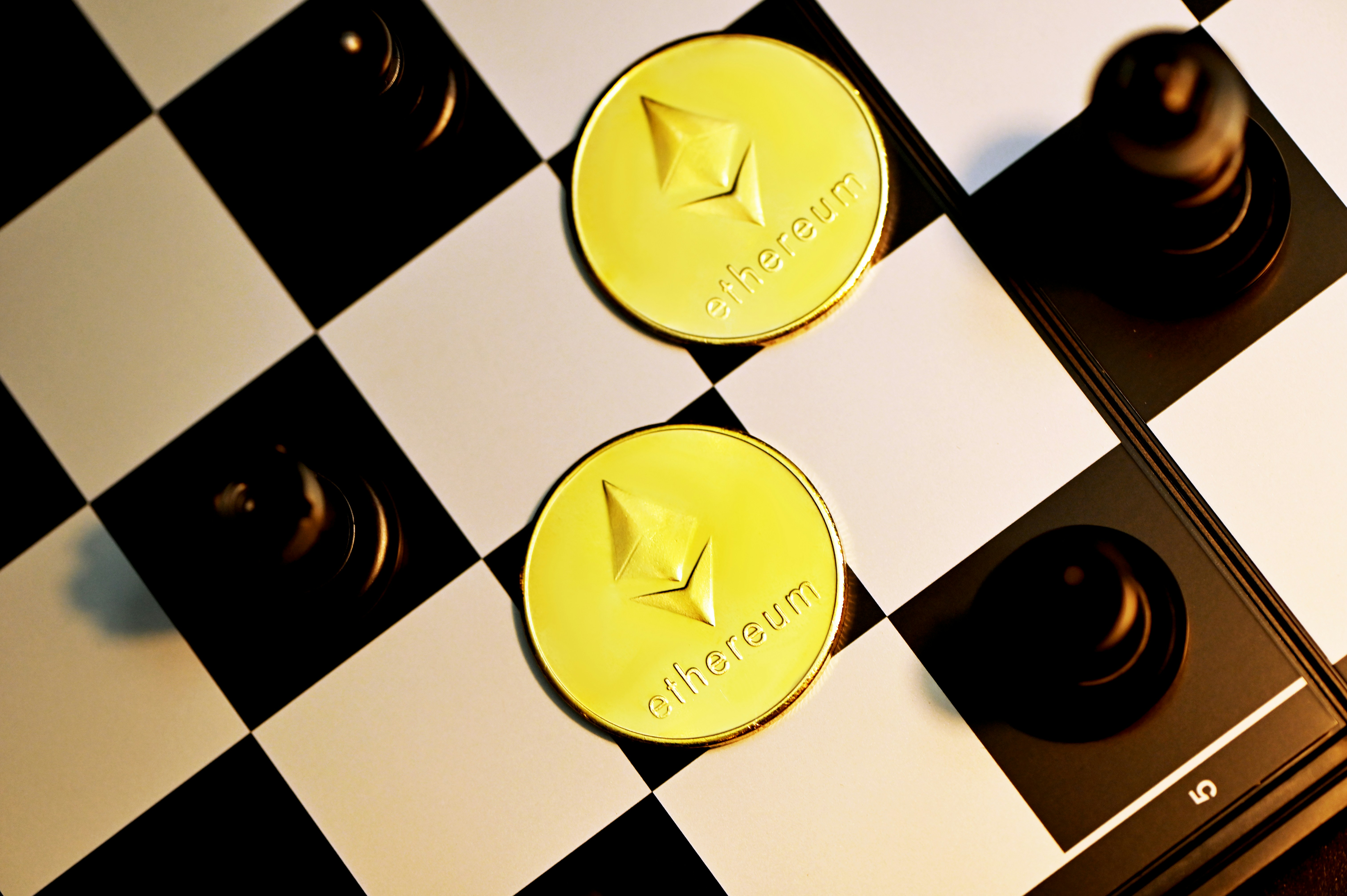 Two Ethereum coins on a chess table
