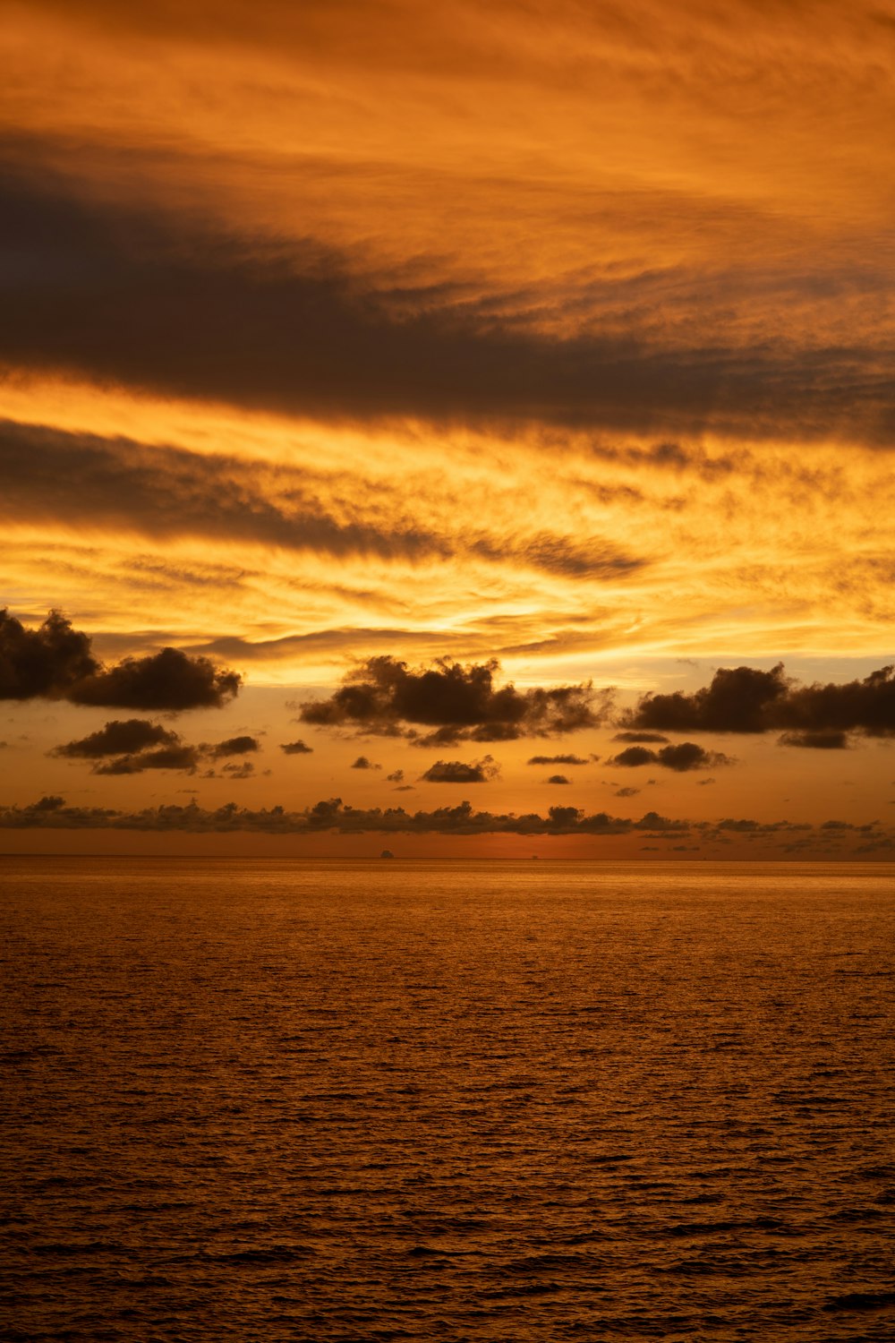 body of water under cloudy sky during sunset