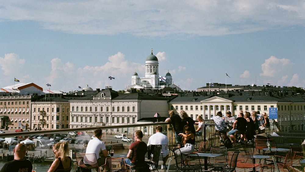 people sitting on chair near white concrete building during daytime