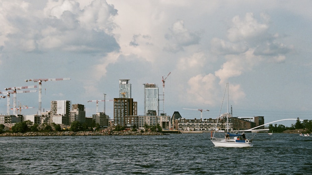 white boat on sea near city buildings during daytime