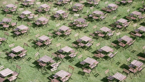 Tables and chairs arranged neatly beside bounce houses for party guests.