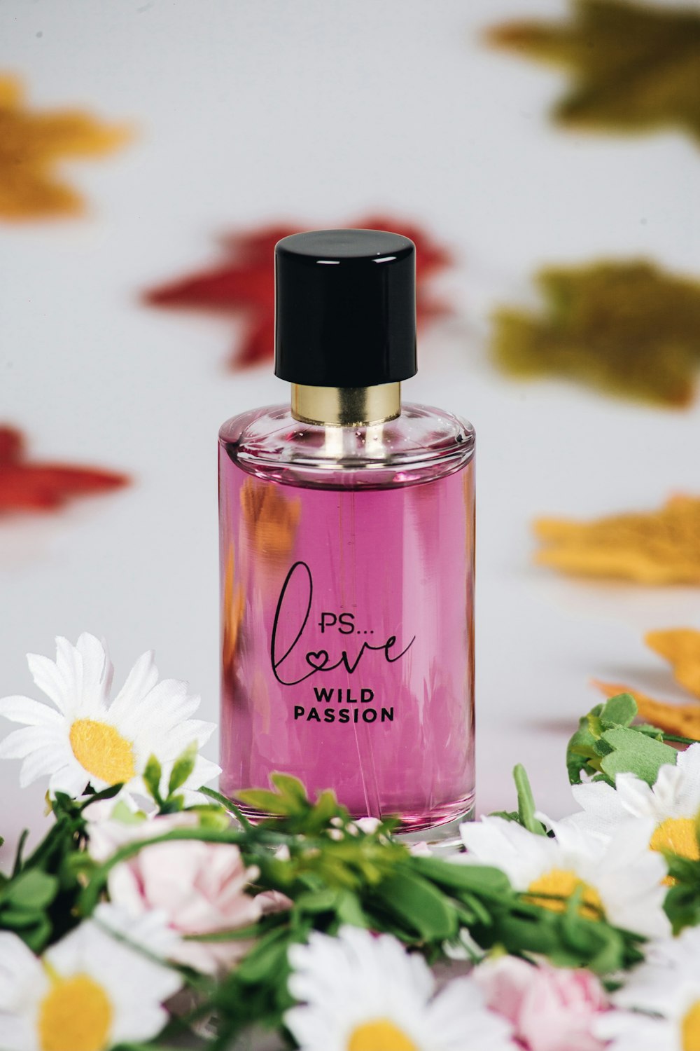 a bottle of perfume sitting on top of a bed of flowers