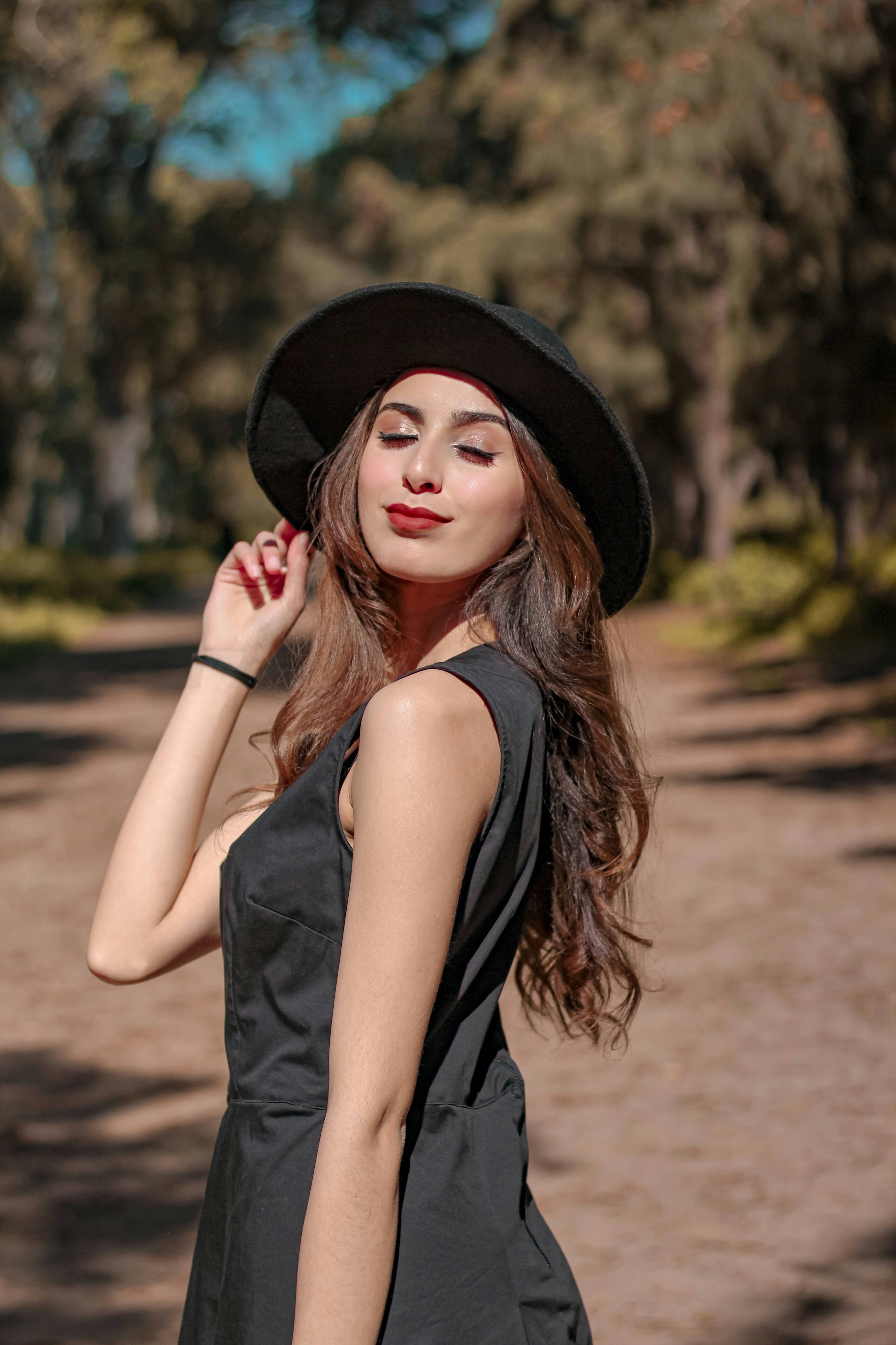 How to Dress for Your Skin Tone: 4 Colors You’re Probably Overlooking – woman in black tank top and black hat