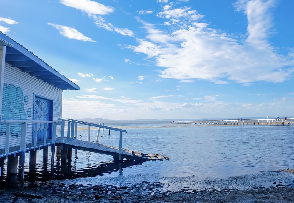 blue wooden dock on sea under blue sky during daytime