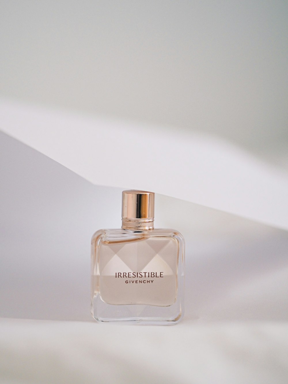 clear glass perfume bottle on white surface