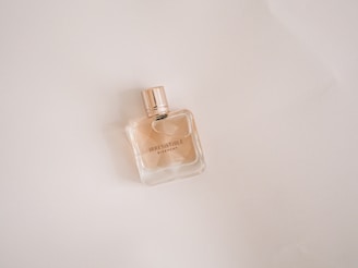 clear glass perfume bottle on white table