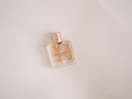 clear glass perfume bottle on white table