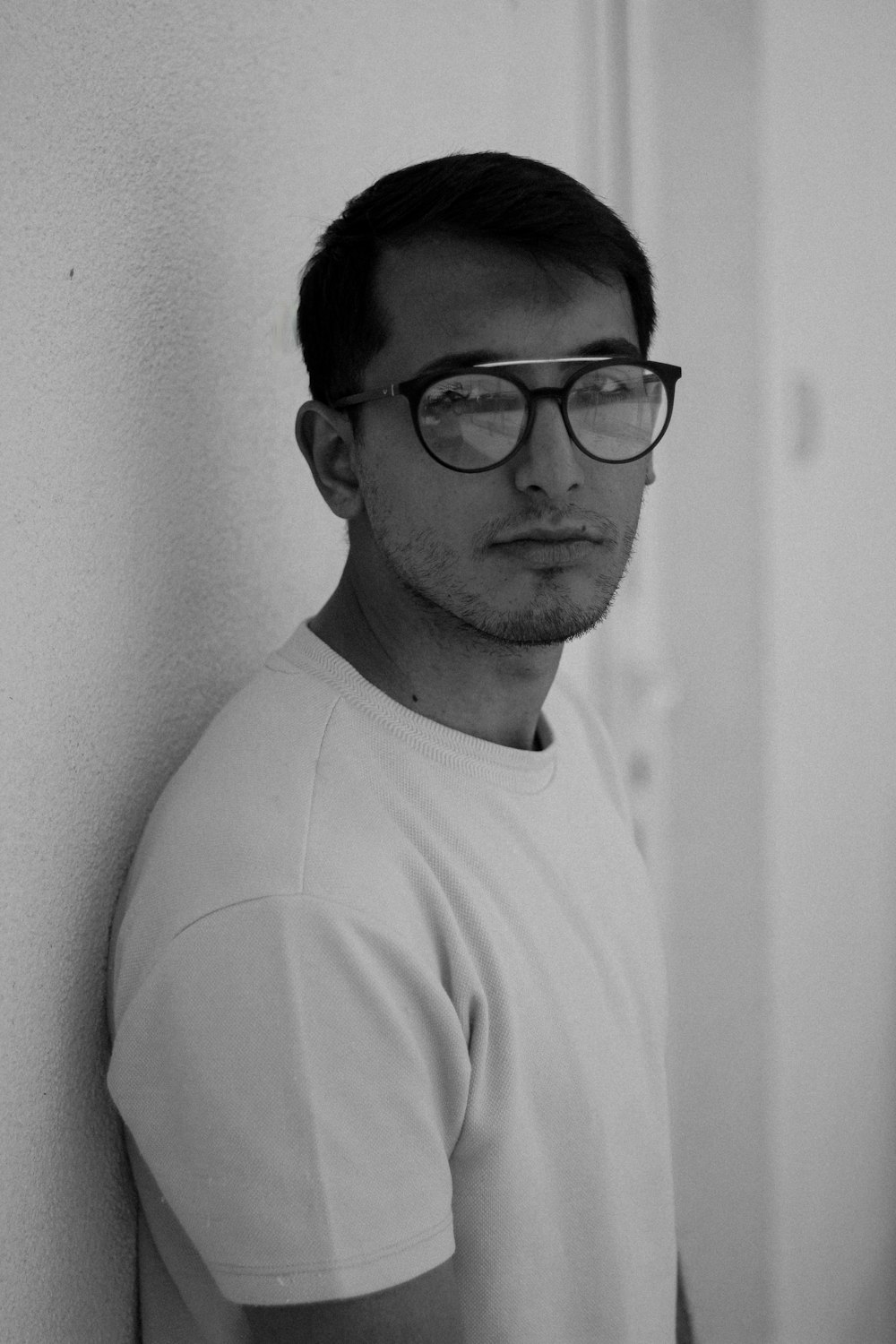 man in white crew neck shirt wearing black framed eyeglasses