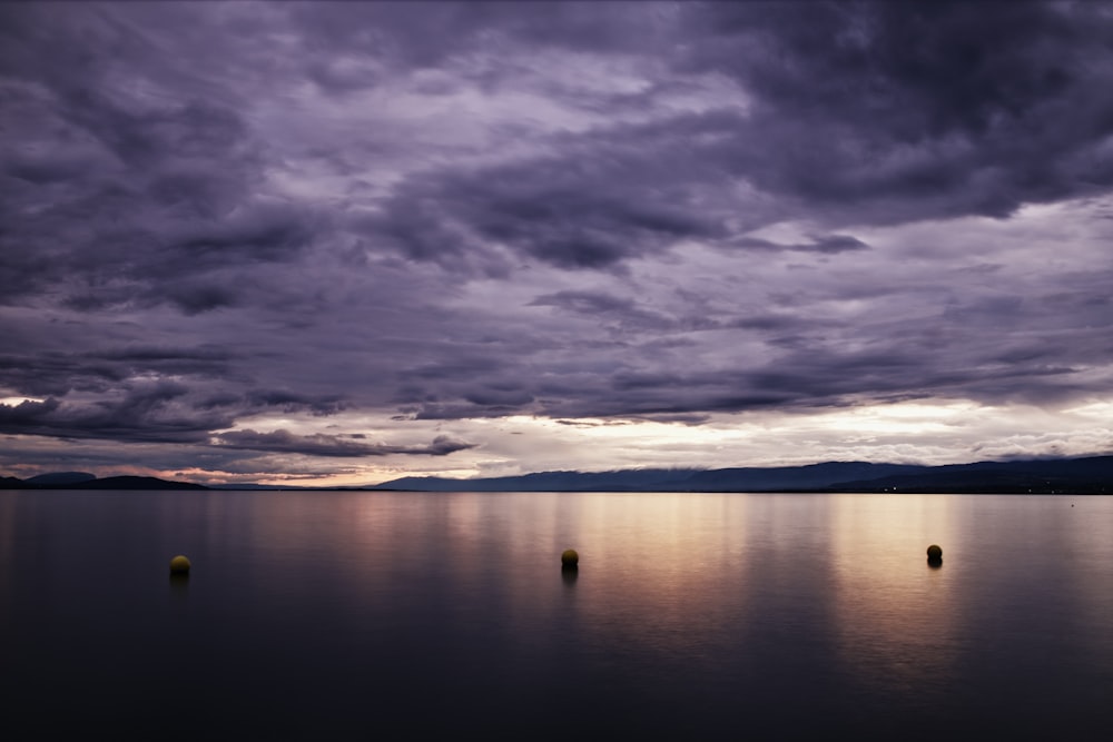 body of water under cloudy sky during sunset