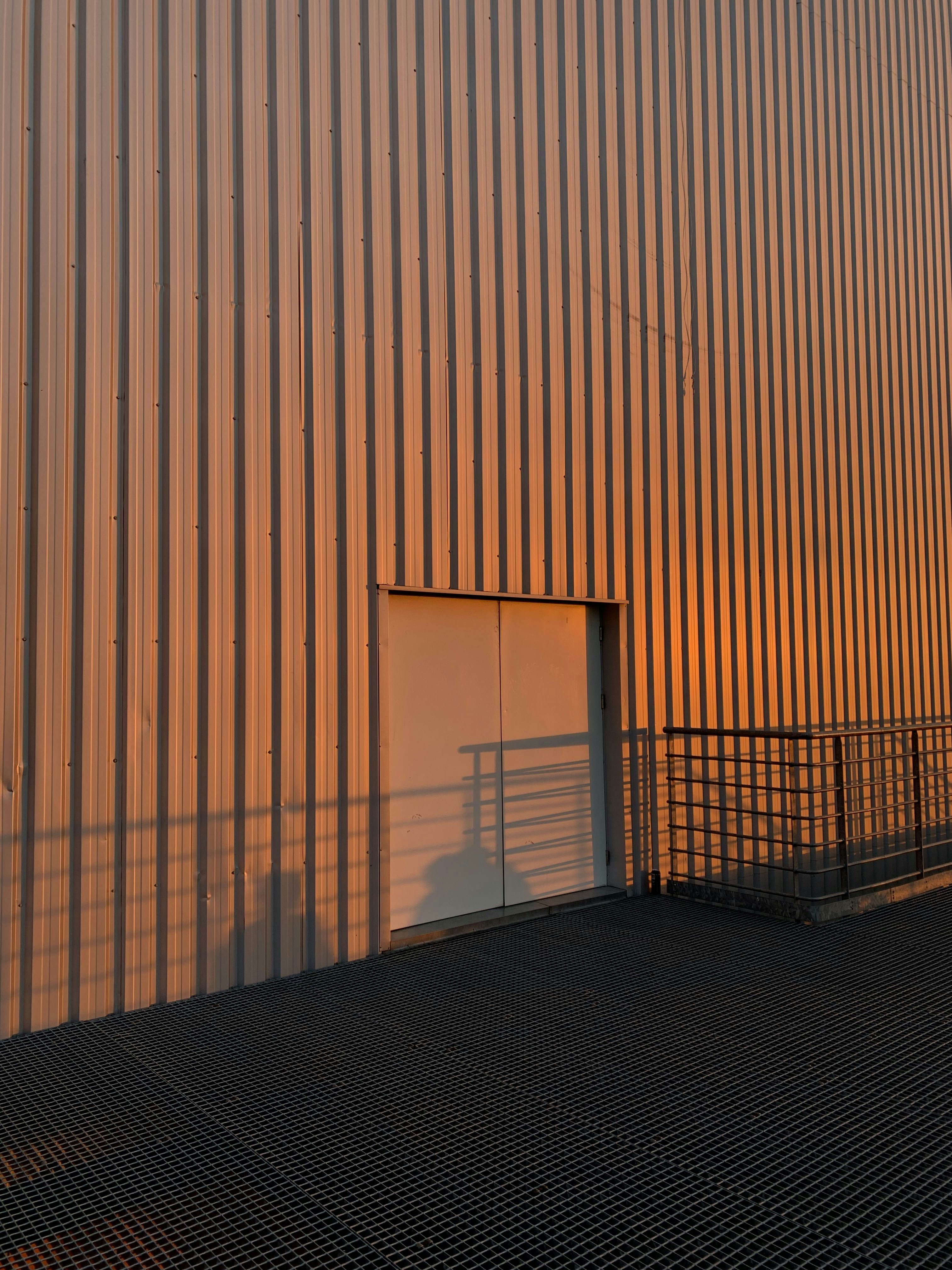 black metal fence near brown wall