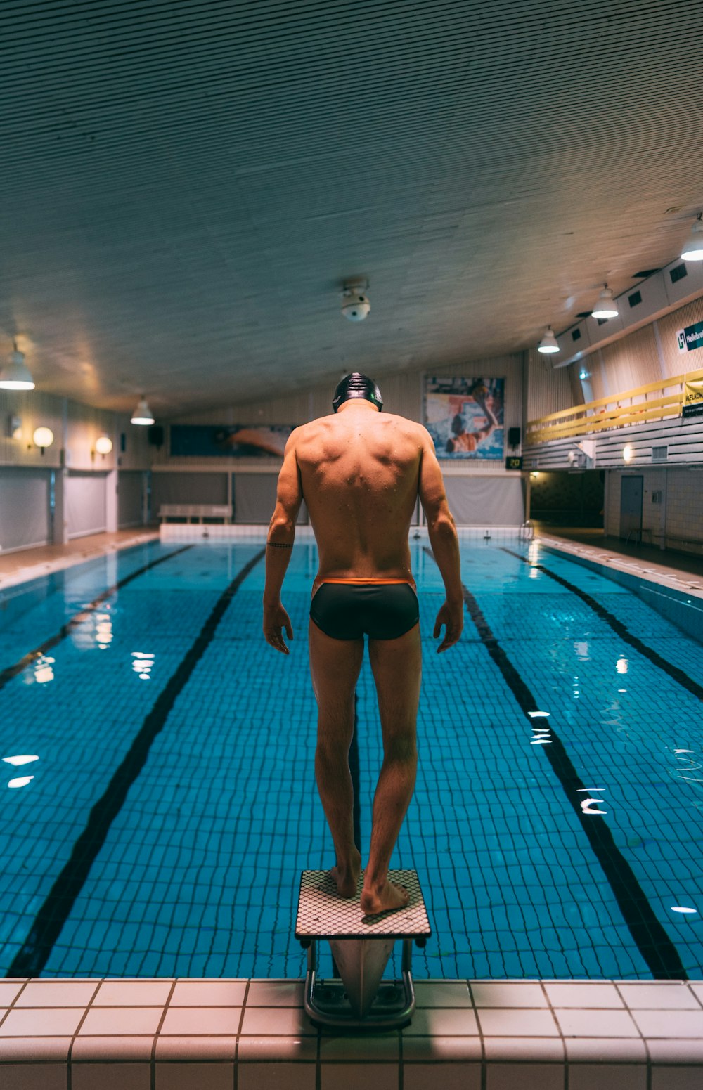 homem em shorts pretos andando em azulejos de piso azuis e brancos