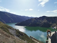 Sunlight reflecting off the calm reservoir behind a hydroelectric dam.