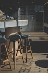 A bar area with elegant stools and ambient lighting.